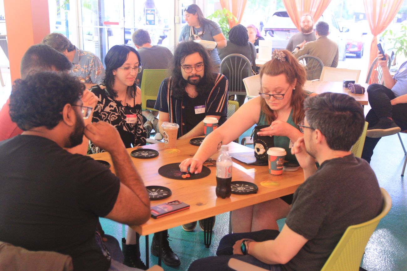 A group playing a game around a coffee-shop table