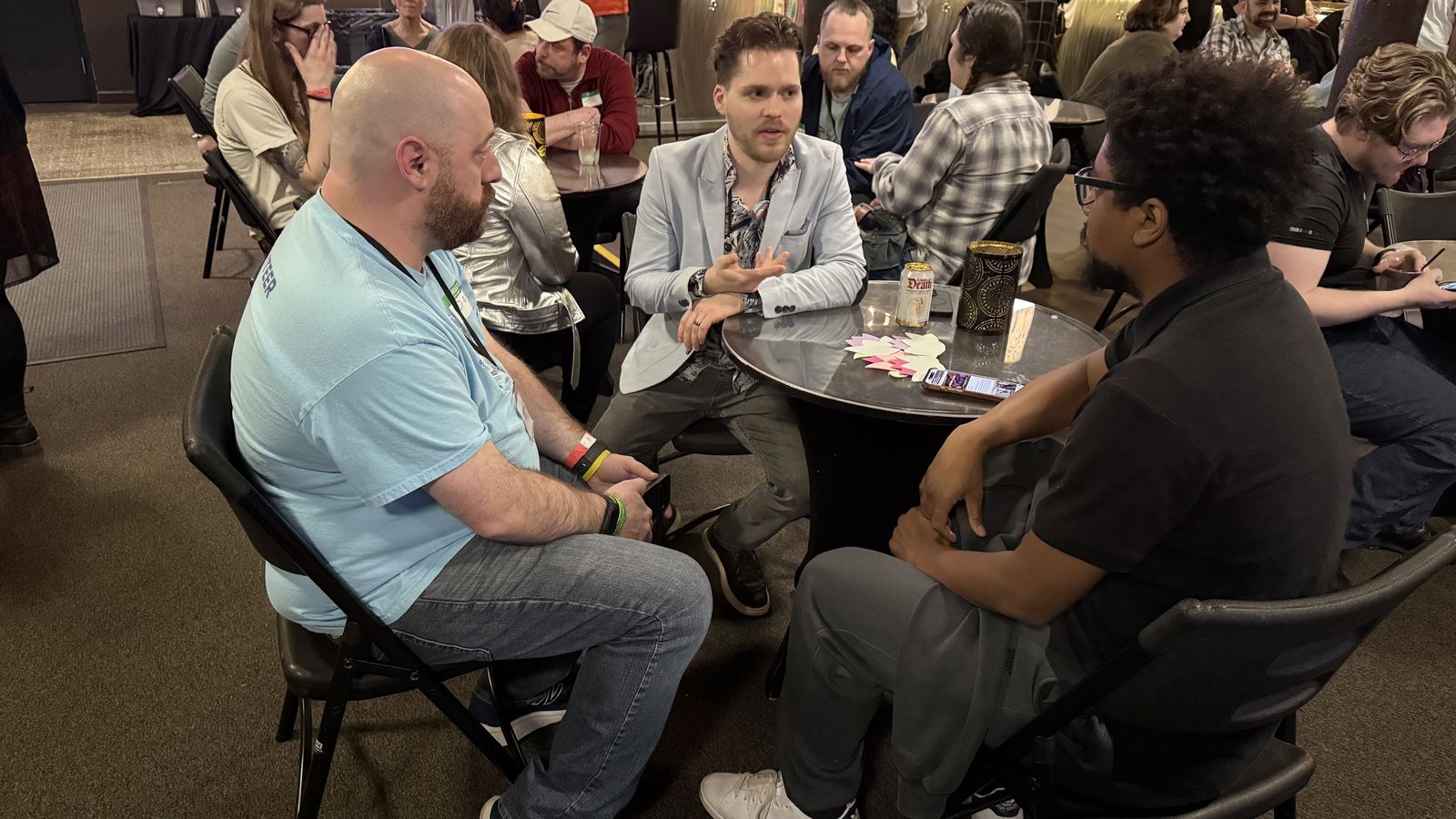 Three people deep in conversation at a Join Dayton meetup