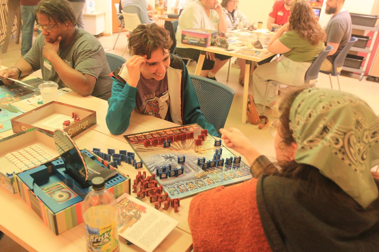 A group playing a coaster game around a table