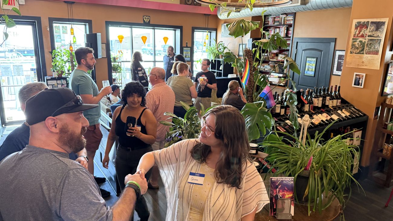 People gathered at a plant-filled wine bar for a Join Dayton meetup